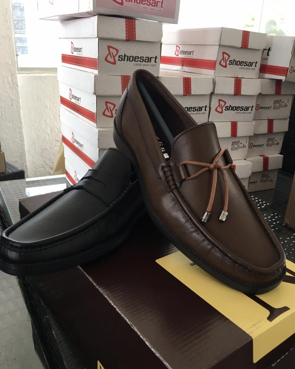 Mocasines de piel de una marca mexicana junto a inventario en el centro de distribución de EnLaTiendita.com